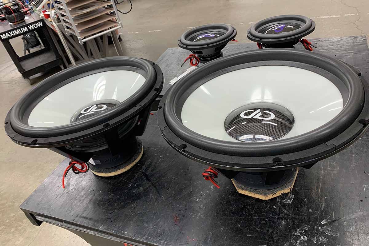 Two USA Made Subwoofers with ghost cones and white DDA logos on high gloss carbon fiber dustcaps