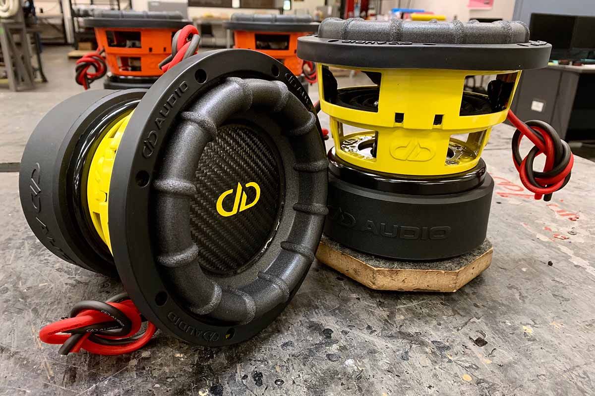 Two USA Made subwoofers with yellow powder coat baskets, black carbon fiber dust caps, yellow DDA logos