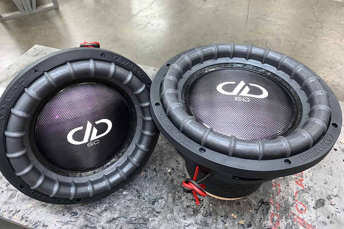 Two USA Made subwoofers with polychromatic purple carbon fiber dust caps, white DDA logos and super charged decals