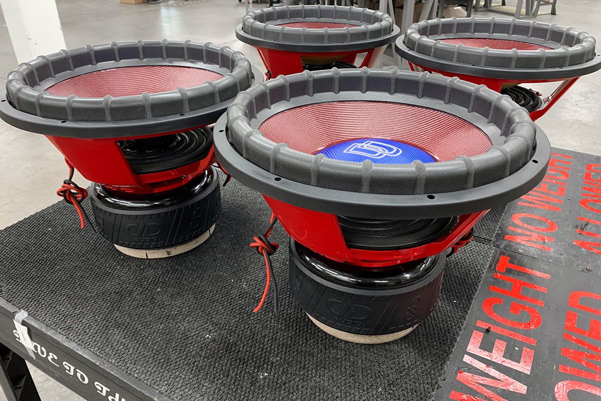 four 18 inch made in usa subwoofers with red powder coated frames and red composite cones and blue composite dust caps with white dd logo