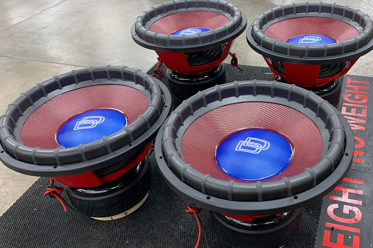 four 18 inch made in usa subwoofers with red powder coated frames and red composite cones and blue composite dust caps with white dd logo