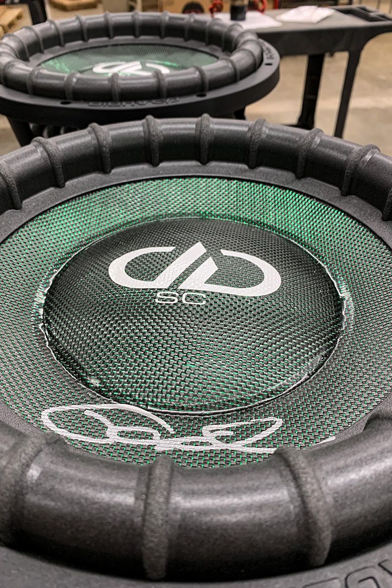 two made in usa subwoofers with emerald green composite dust cap and cones with white DD and supercharged logos with silver signature