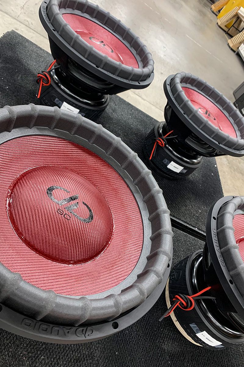 four 15 inch made in usa subwoofers with red composite cone and dust caps with flat black DD and supercharged logos